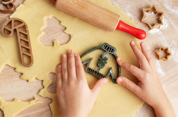 Children's hands with gingerbread cookies on wooden background
