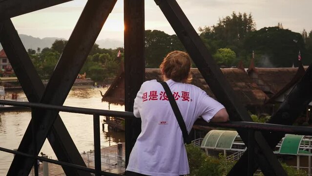 Female European Tourist Visiting The Death Railway (Siam-Burma Railroad Bridge) Overlooking The Khwae Yai River In Kanchanburi, Thailand.