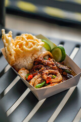 The appearance of fried squid chili sauce with rice, crackers and cucumber is very delicious