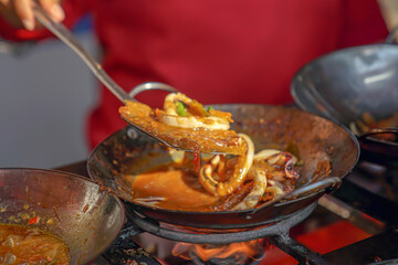 The process of making squid sauce while removing the squid in a frying pan