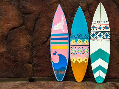 Flashy pattern surfboard against the rock wall.