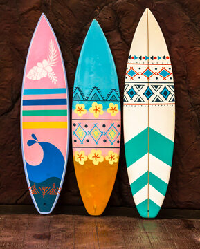 Flashy pattern surfboard against the rock wall.
