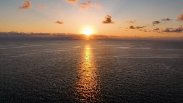 Amazing orange sunrise over calm sea filmed by drone