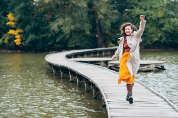 Woman walking on a bridge on a lake in autumn in Prague