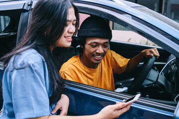 Young asian woman traveler talking with taxi driver explain the route of destination. 