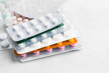 Pile of various pills and tablets in a blister pack on white background, healthcare and medicine concept