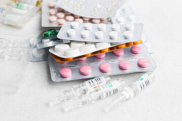 Pile of various pills and tablets in a blister pack on white background, healthcare and medicine concept