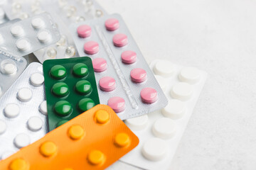 Pile of various pills and tablets in a blister pack on white background, healthcare and medicine concept