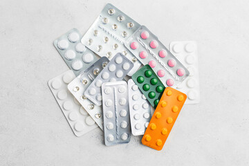 Pile of various pills and tablets in a blister pack on white background, healthcare and medicine concept, top view