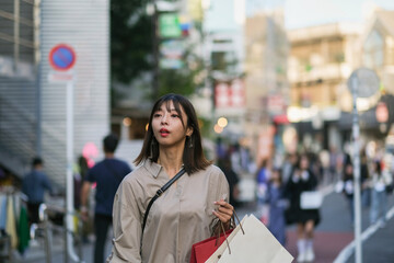 ショッピングバッグを持って街を歩く女性