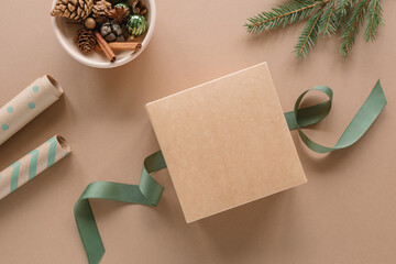Top view of stylish holiday background with Christmas gift box mockup, wrapping papers, green...