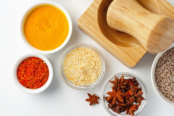 Wooden mortar with spices on white background