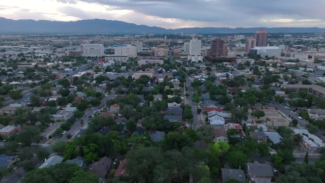Albuquerque, New Mexico during sunrise. Aerial truck shot above residential suburb. Skyline and mountains in background.