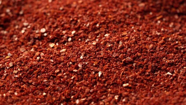 close up Korean dry red pepper flake powder coarse chili ground Gochugaru background food footage rotate