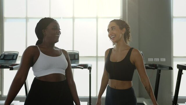 Smiling, Laughing Female personal trainer with her client giving high five.
