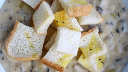 Creamy soup topped with slices of bread.
