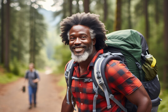 Man with beard and backpack is walking down dirt road. This image can be used to depict adventure, travel, exploration, or hiking.