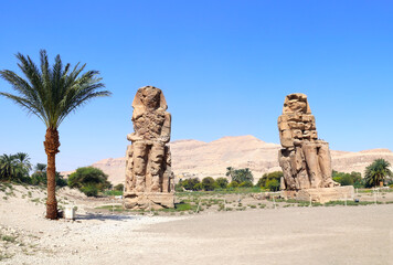 Famous Colossi of Memnon, Valley of Kings, Luxor, Egypt. Ancient stone statue of Pharaoh Amenhotep III in Theban Necropolis