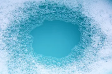 Fotobehang Detergent foam bubble on water. Blue background, Soap sud © Bowonpat