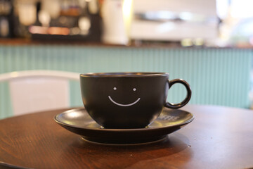 black coffee cup with smile shape design on it 