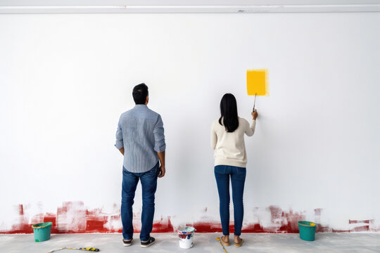 Happy young couple renovating house.