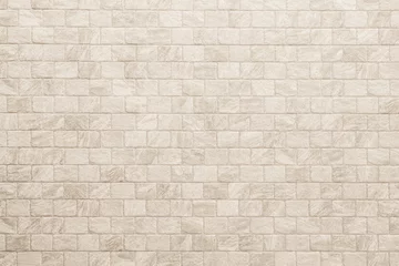 Fotobehang Empty background of wide cream brick wall texture. Beige old brown brick wall concrete or stone textured, wallpaper limestone abstract flooring. Grid uneven interior rock. Home decor design backdrop. © Manitchaya