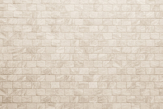 Fototapeta Empty background of wide cream brick wall texture. Beige old brown brick wall concrete or stone textured, wallpaper limestone abstract flooring. Grid uneven interior rock. Home decor design backdrop.