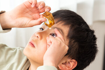 目薬をさす男の子