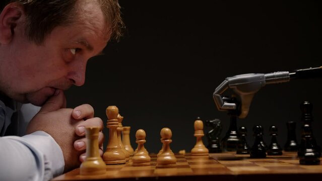 Man playing chess with robot. Human mind versus artificial intelligence.
