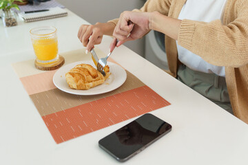 Happy woman having breakfast crispy croissants