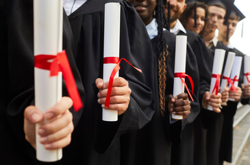 University students with diplomas in hands. Group of young people holding educational certificates...