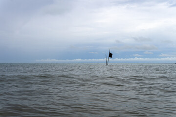 Fototapeta na wymiar A lonely flag in the sea. Open space. Koh Samui