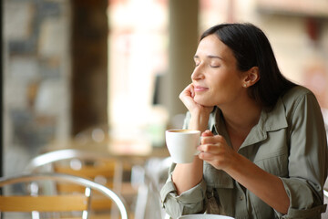 Woman relaxing drinking coffee in a terrace - obrazy, fototapety, plakaty