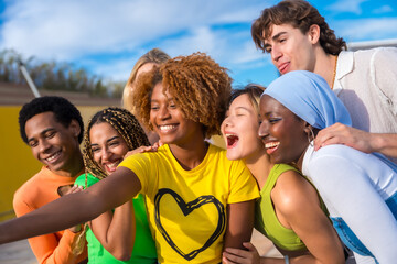 Multi-ethnic friends smiling and taking a selfie outdoors