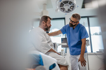 Supportive doctor soothing a worried overweight patient, discussing test result in emergency room. Illnesses and diseases in middle-aged men's health. Compassionate physician supporting stressed - Powered by Adobe