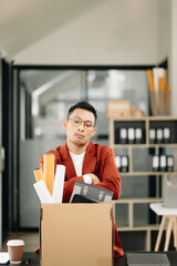 Happy and excited young  Asian man office worker celebrating her resignation, carrying her personal stuff. leaving job, changing or company.in office