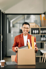 Happy and excited young  Asian man office worker celebrating her resignation, carrying her personal stuff. leaving job, changing or company.in office