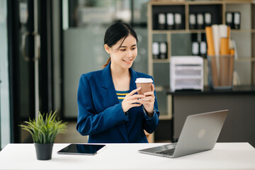 Asian businesswoman working in the office with working notepad, tablet and laptop documents