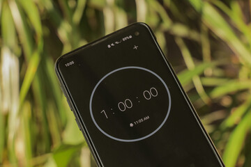A phone with a black and white 60-minute timer to study with the pomodoro method on a blurry...