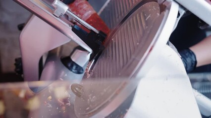 Butcher cutting Spanish chorizo with a slicing machine