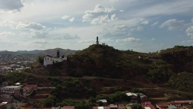 Frontal drone shot of a mine in El Parral Chihuahua, Mexico, discovering the city in the background