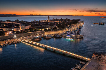 Zadar, Croatia - Aerial view of the old town of Zadar at golden sunset sky with illuminated City...