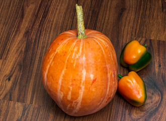 Close up shot of the pumpkin and capsicums on the wooden table. Vegetables