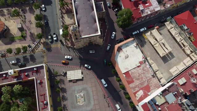 Overhead shot of a vehicular intersection with moving cars, zooming in with the drone