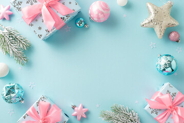 Festive holiday gifts adorned with seasonal decorations. Top-view of baubles, sparkling star, Santa's presents, frosty fir branches on a pastel blue background, leaving frame for text or advertising