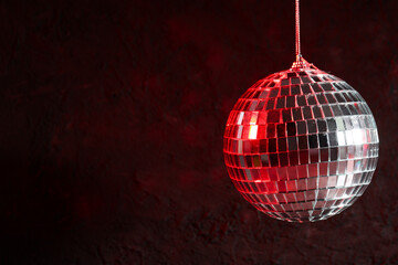 The disco ball is illuminated with red light