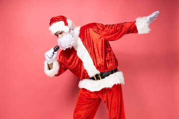 Fototapeta na wymiar Santa Claus, singing into a microphone, on a pink background.