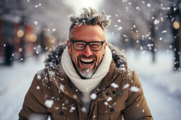Portrait of a cheerful happy excited satisfied adult man outdoors rejoicing wintertime and snowfall - obrazy, fototapety, plakaty