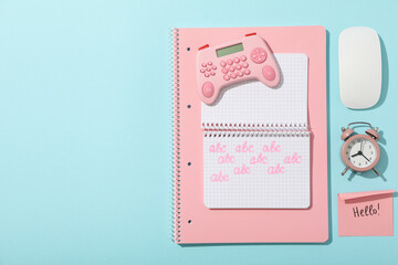 Notepads, alarm clock, joystick and note on blue background, space for text