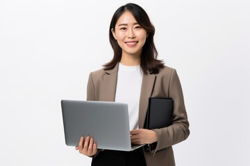 Cheerful beautiful freelancer dressed in elegant suit working on project. Young professional woman entrepreneur laughing and checking e-mails on laptop while standing on white background.